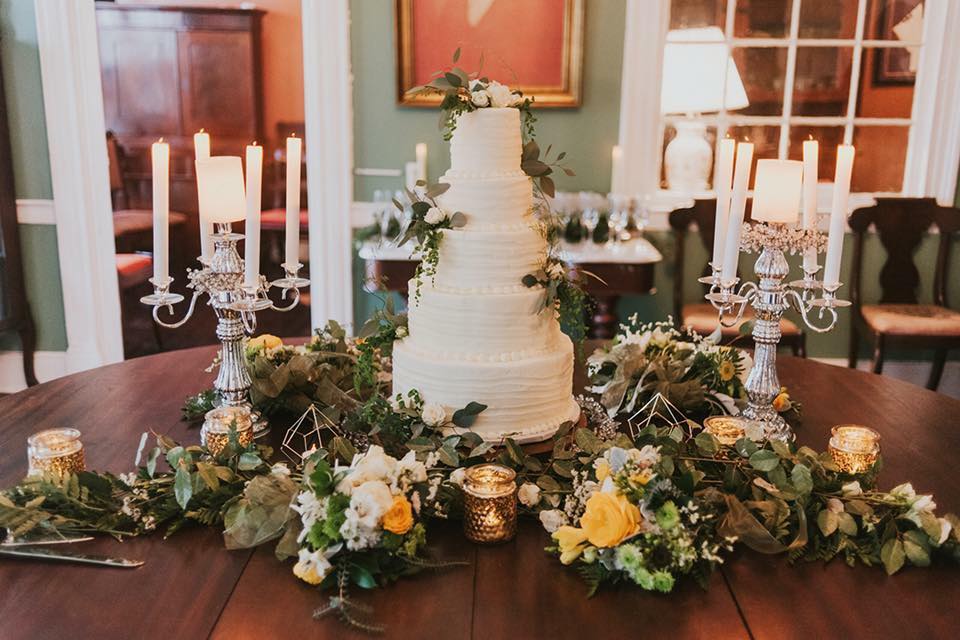 Wedding cake amidst floral setting and candles