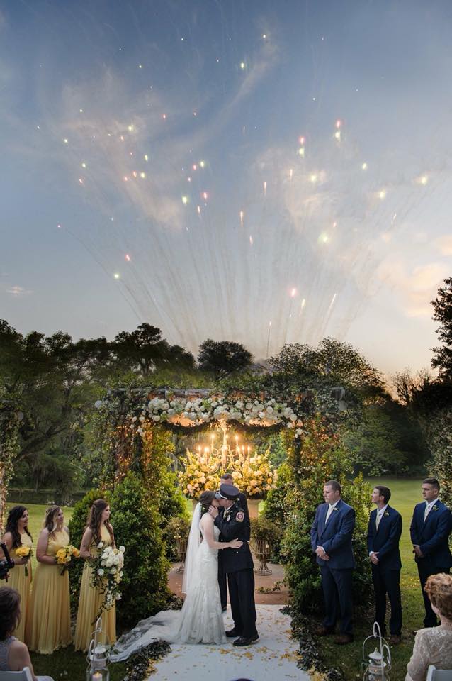 Bride and groom kissing with fireworks going off